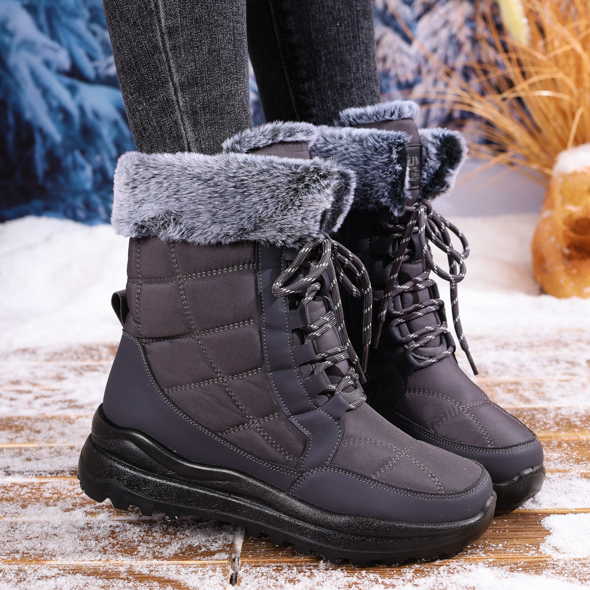 Gray winter boots with fuzzy lining on a wooden surface