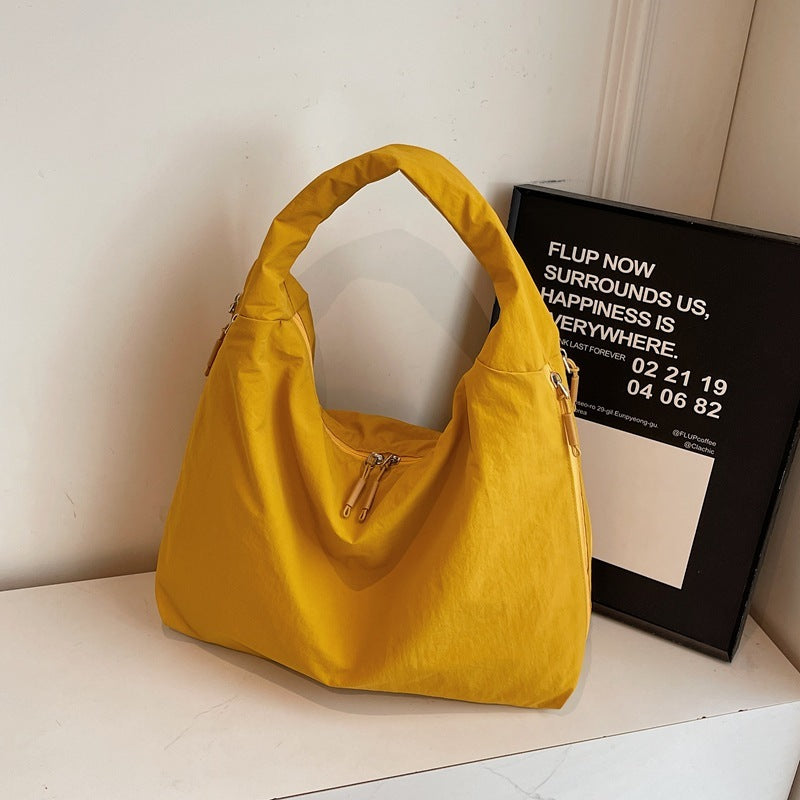 Yellow handbag on a white surface with a black frame in the background