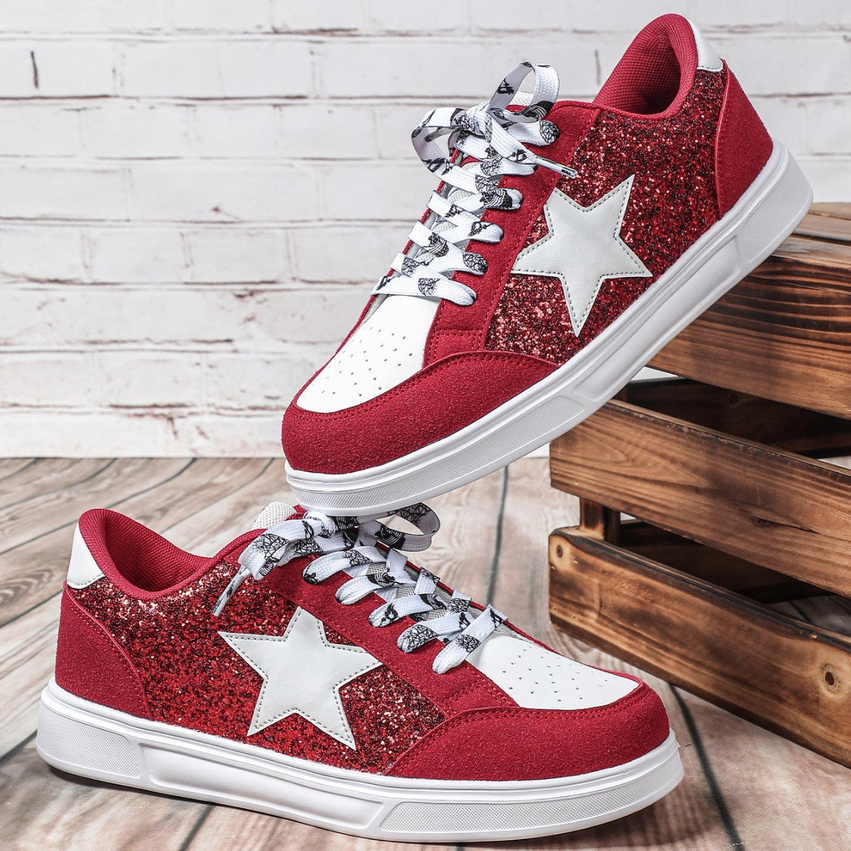 Red glitter sneakers with white stars on a wooden floor.