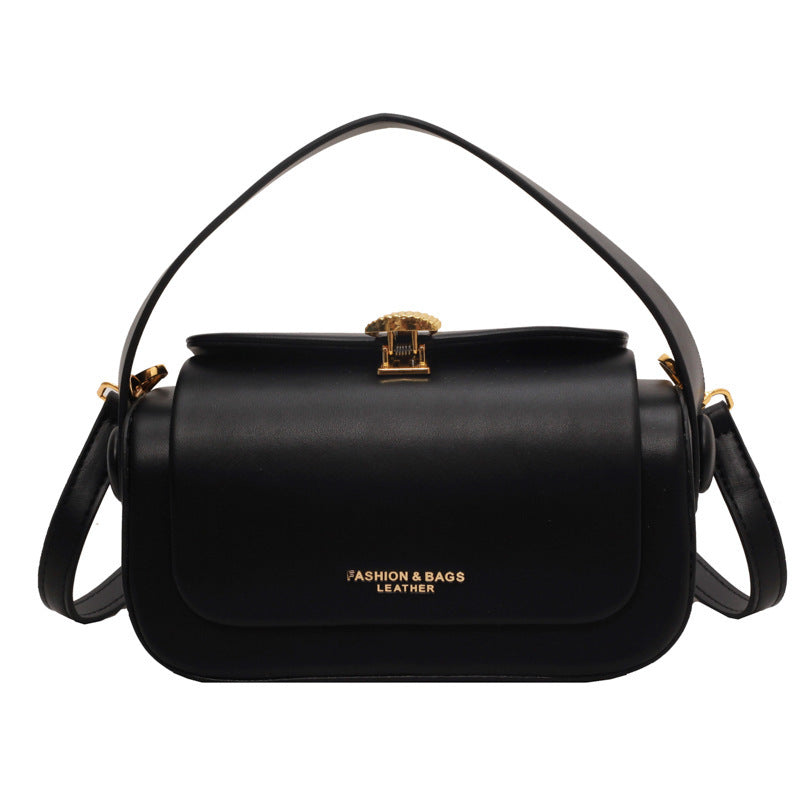 Black handbag with gold accents on a white background