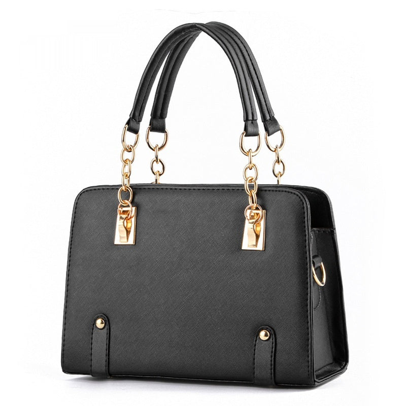 Black handbag with gold accents on a white background