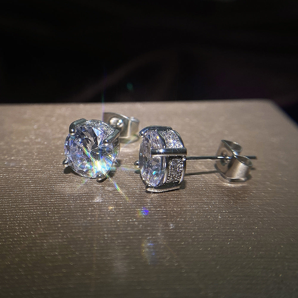 Pair of diamond stud earrings on a dark surface