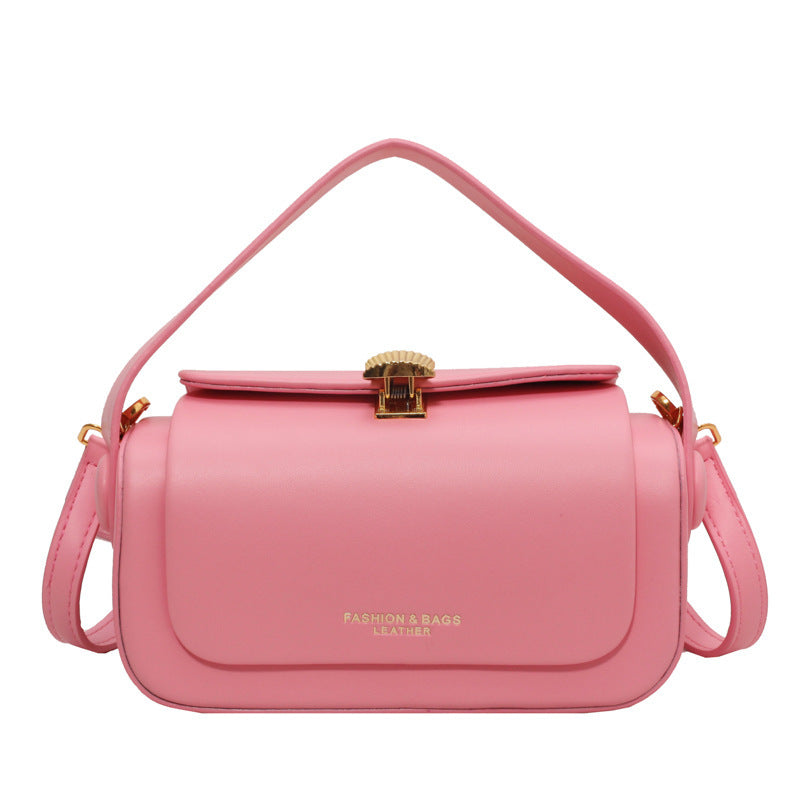 Pink handbag with gold accents on a white background