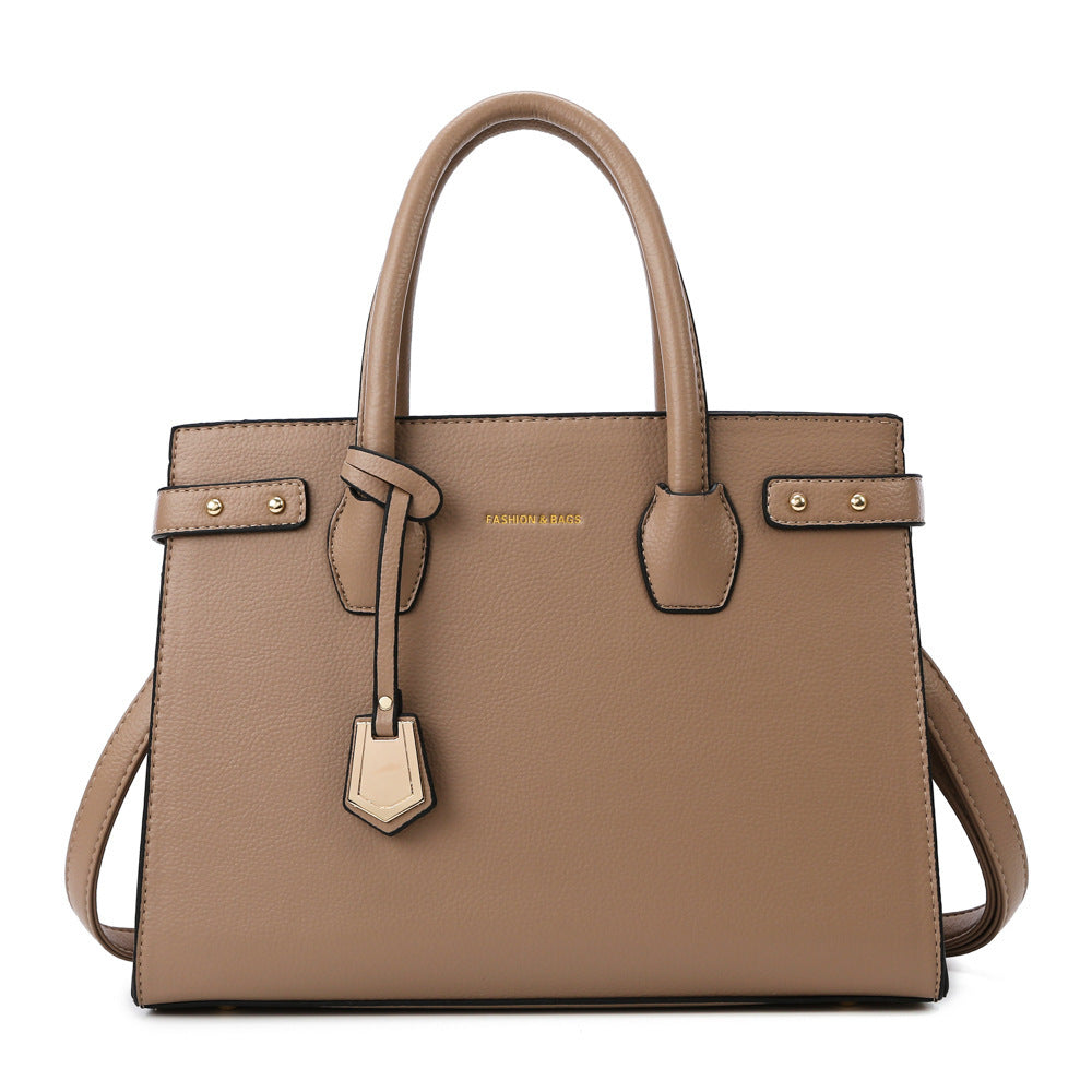 Brown handbag with gold accents on a white background