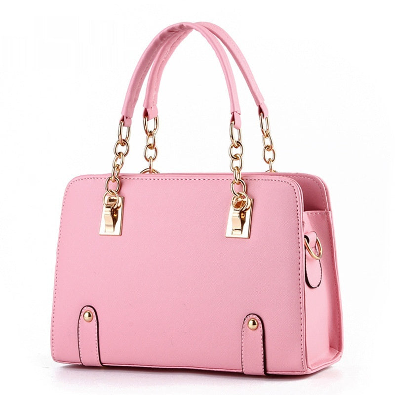 Pink handbag with gold accents on a white background
