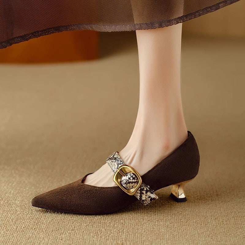 Brown high-heeled shoes with decorative buckle on a beige background