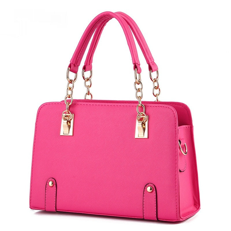 Pink handbag with gold accents on a white background