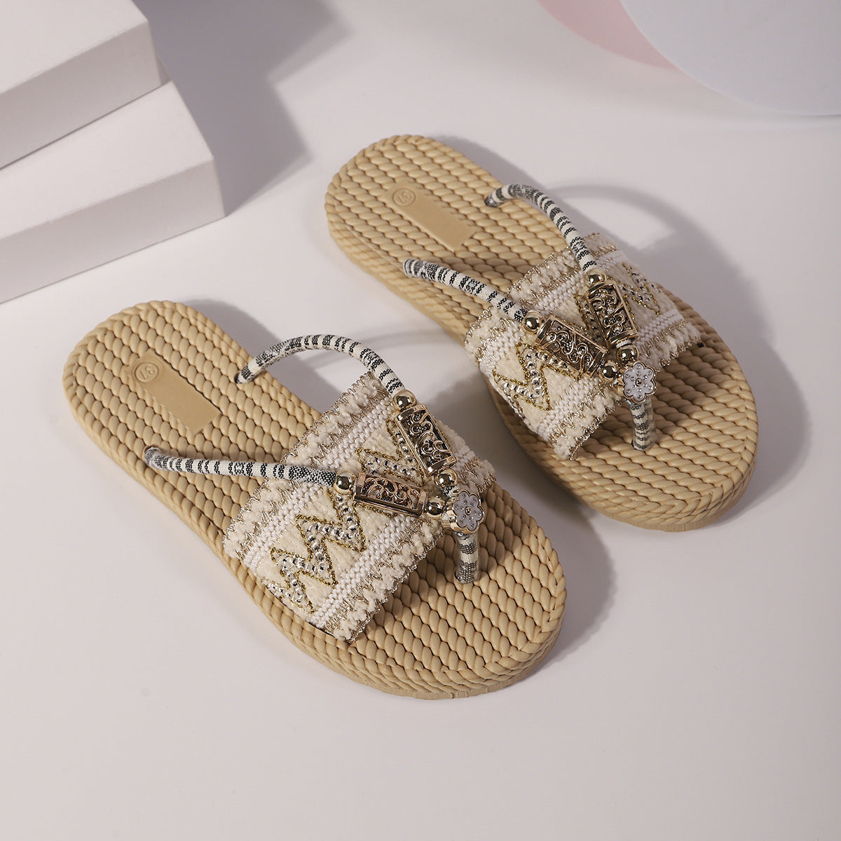 Beige sandals with decorative elements on a light background
