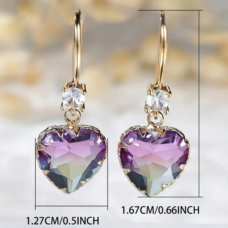 Heart-shaped earrings with purple and clear gemstones on a blurred background