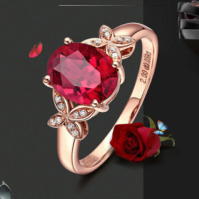 Rose gold ring with a large red gemstone on a dark background