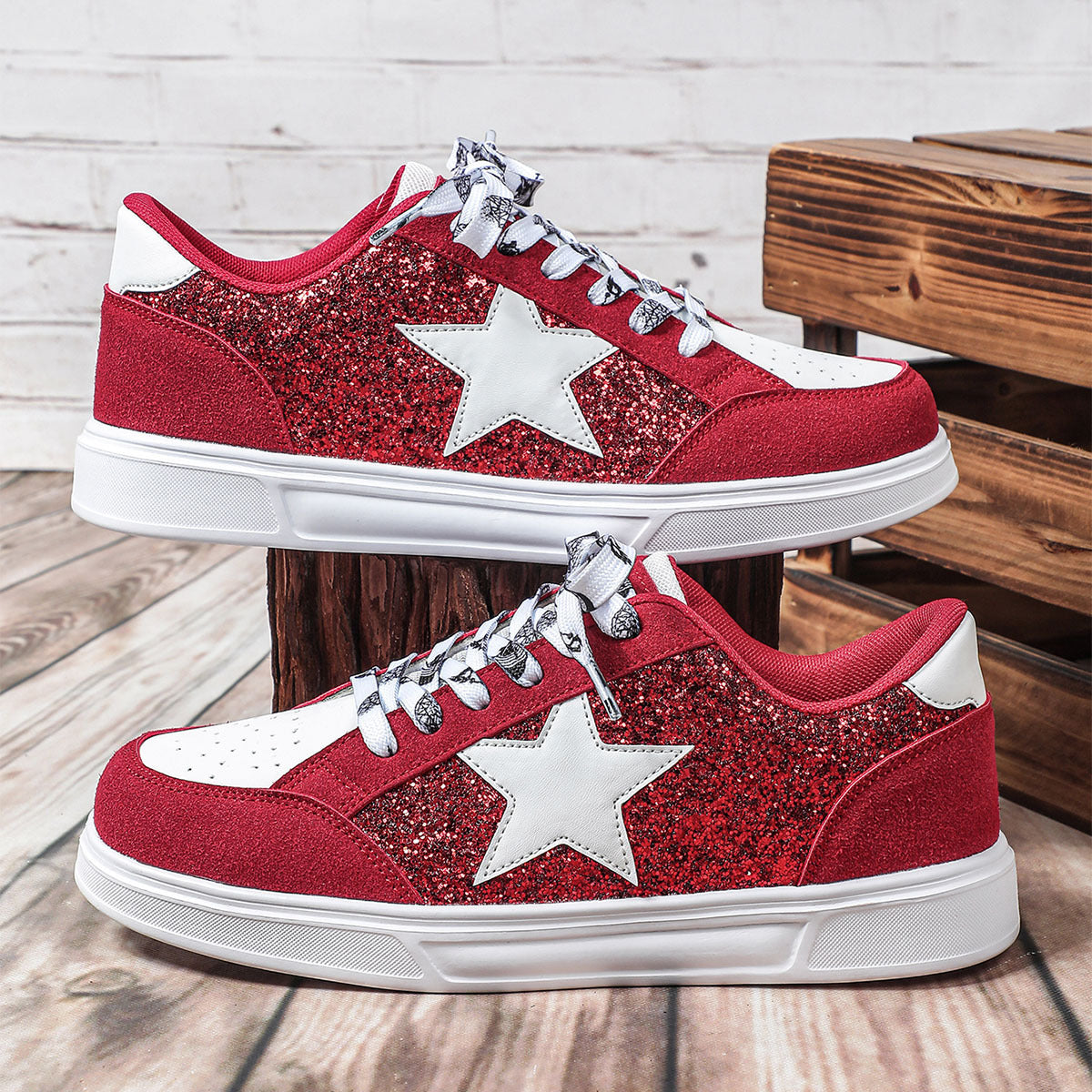 Red glittery sneakers with white stars on a wooden floor.
