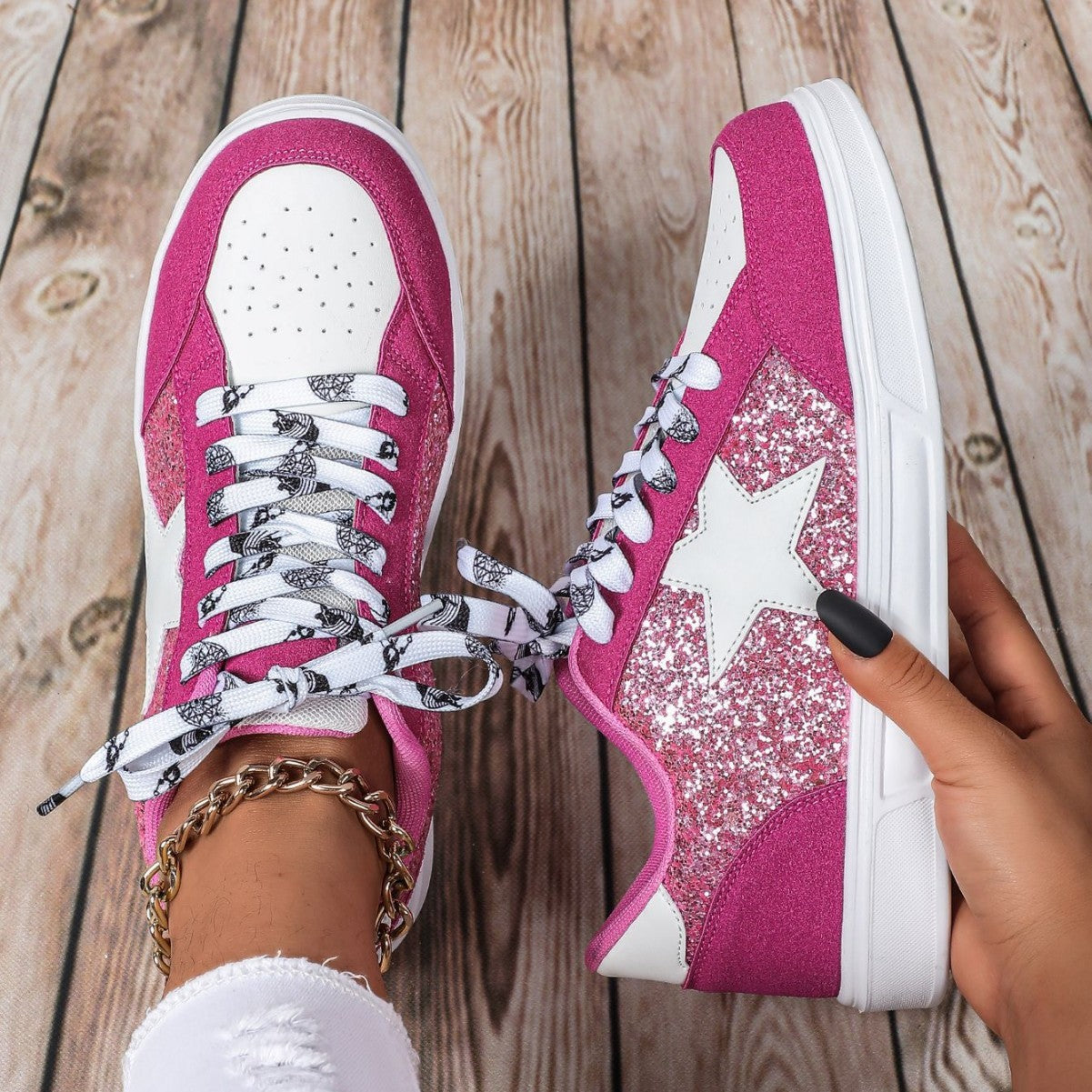 Pink sneakers with white stars on a wooden floor